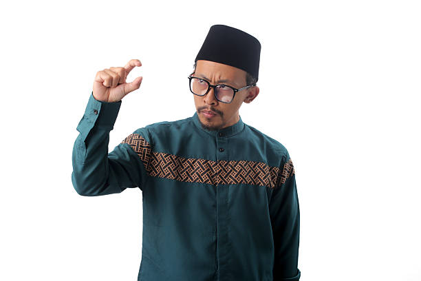 istock Displeased Asian Muslim Man Gesturing with Hand Doing Small Size Sign 2211526769