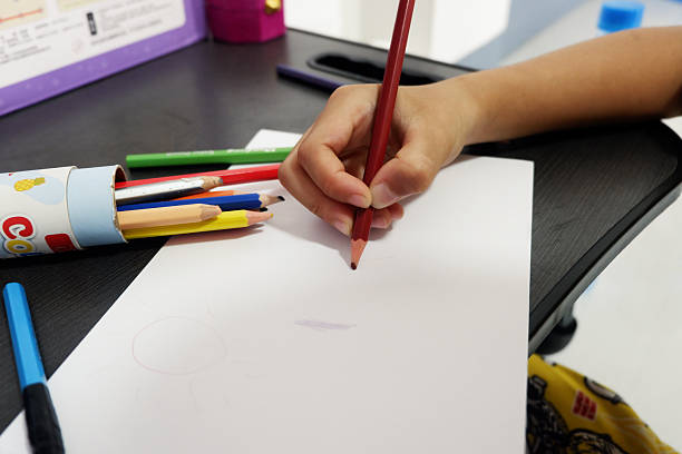 istock A boy's hand is practicing drawing shapes on paper. 2211528474