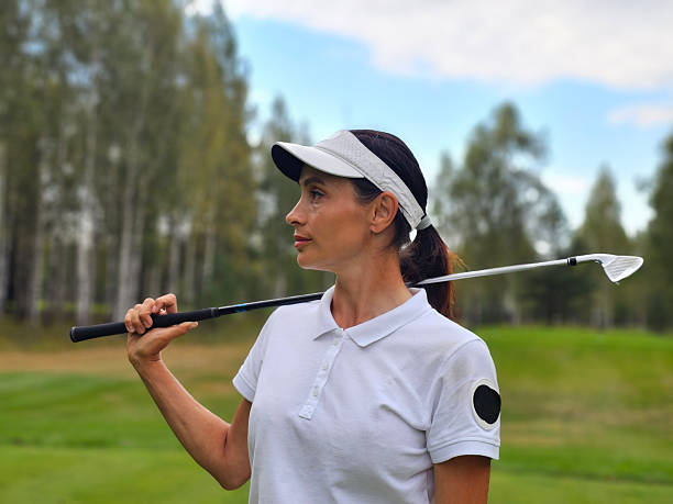 istock Golf player poses on the course while holding a club against a backdrop of trees 2211528828