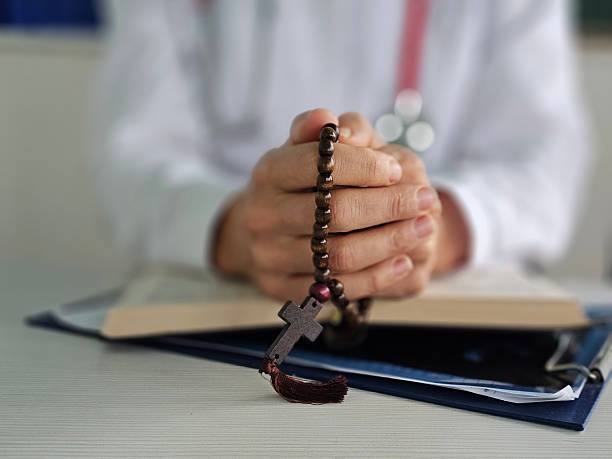 istock Praying hands clasped over a book with a rosary in a serene setting during a moment of reflection concept 2211529920