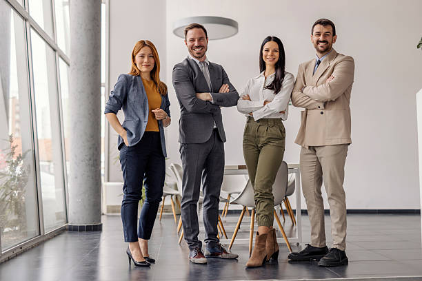 istock Full length of executives standing at enterprise and smiling at camera. 2211531049