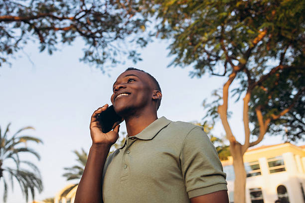 istock Happy young man making a phone call outdoors under the trees 2211532746