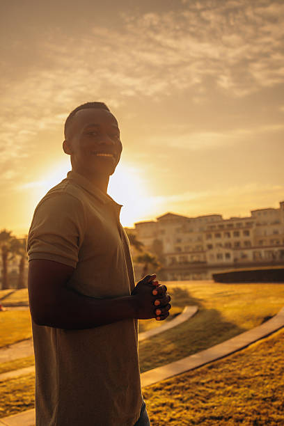 istock Man smiling outdoors during golden sunset in a serene urban garden setting 2211533046