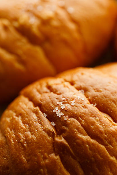 Close up plate of Shio Pan, Japanese salted butter rolls on brown baking paper.