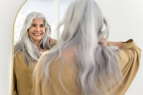 istock Happy positive elderly Hispanic woman mirror reflection and back view 2211535376