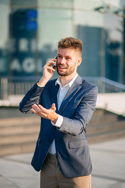 istock Confident  Businessman with a smile standing holding notepad and tablet at out side office. big city on business center 2211535571