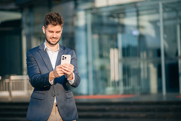 istock Confident  Businessman with a smile standing holding notepad and tablet at out side office. big city on business center 2211535592