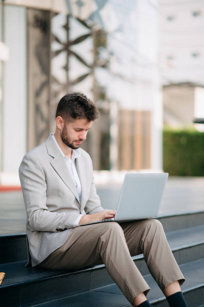 istock Businessman standing outdoors and using digital tablet. Perfect for corporate, technology, and professional themes 2211535615