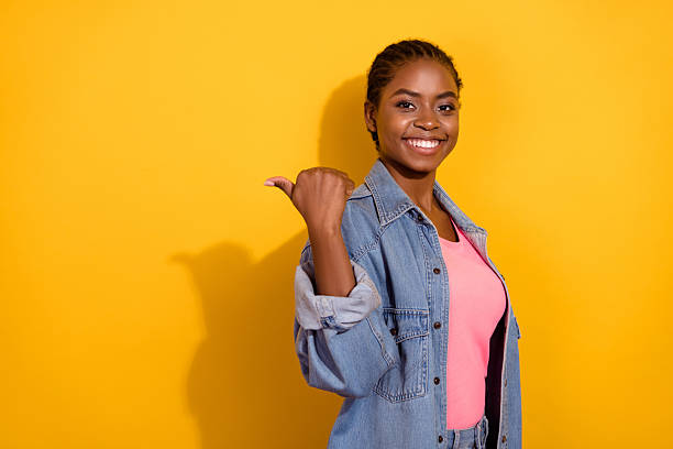 istock Profile side photo of young lady indicate thumb empty space direct promo suggest isolated over yellow color background 2211536152
