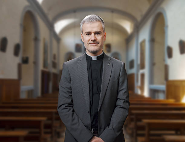 Selective focus shot of senior Caucasian priest sitting on pew supporting sad African American male parishioner