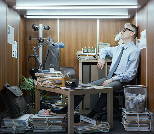 istock Depressed businessman working in a tiny messy office 2211541251