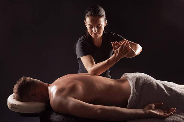 istock Professional therapist giving back massage to male client for deep relaxation and stress relief. 2211541788