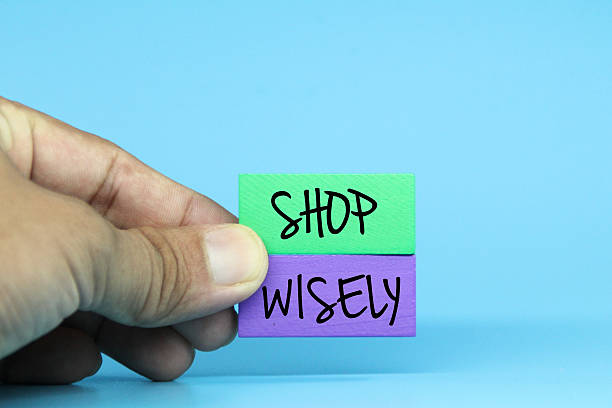 istock hands holding colored blocks with the word shop wisely. Selective focus 2211541802
