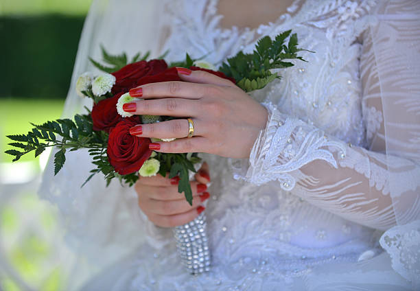 Beautiful wedding bouquet of flowers in the hands of the newlyweds