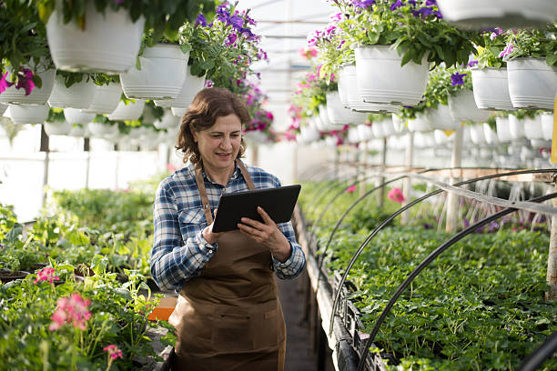 istock Senior florist holding digital tablet and checking the flowers 2211542317