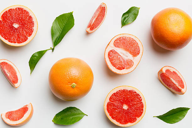 istock fresh Fruit grapefruit with Juicy grapefruit slices on colored background. Top view. Copy Space. creative summer concept. Half of citrus in minimal flat lay with copy space 2211543612