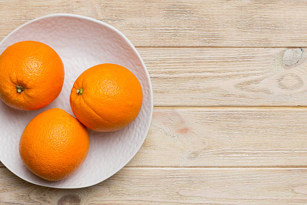 istock Flat lay of Fresh orange fruit with sliced in plate on Colored background. Top view with copy space 2211543620