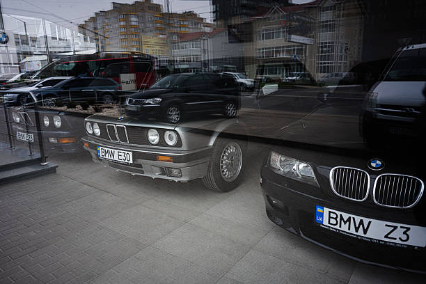 Khmelnytskyi, Ukraine - April 16, 2025: BMW cars showcased in showroom environment with reflections capturing the street outside.