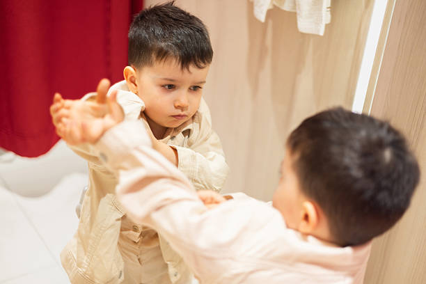 Boy playing with door viewer, showing curious and happy child looking through peephole. Childhood exploration and home safety concept.