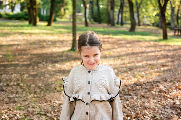 istock Cute girl making a face in park 2211550578