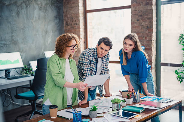 istock Colleagues Collaborating on a Project in a Bright, Modern Office Space with Stylish Casual Attire and Friendly Atmosphere 2211550665