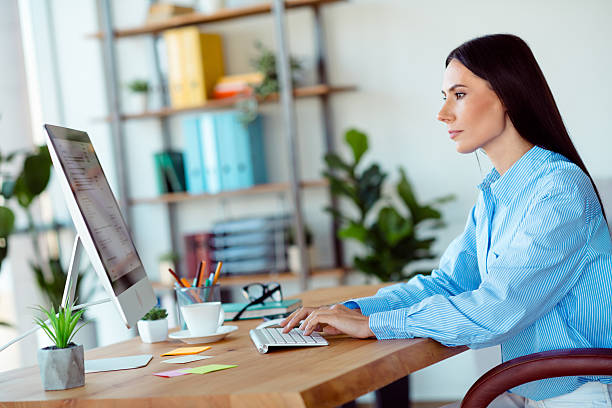 istock Focused businesswoman working at a desk in a modern office with a computer and organized workspace. 2211551161