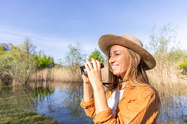 istock Woman Birdwatching in a Wetland with Binoculars 2211551200