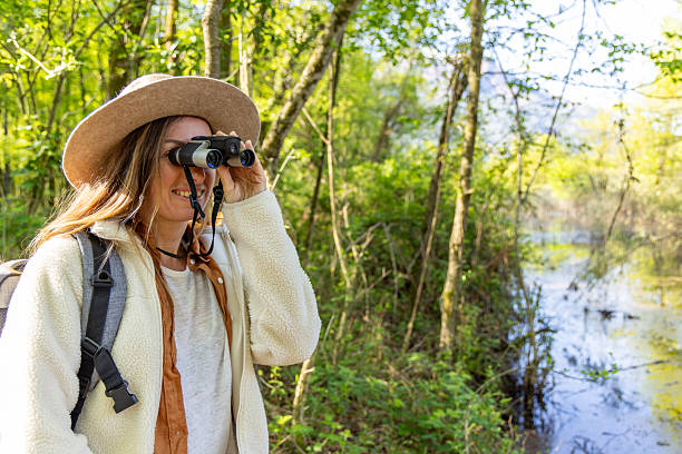 istock Female Birdwatcher Observing Wildlife in Forest 2211551806