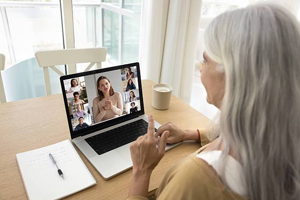 istock Speaking older freelancer woman talking on group training video call 2211551972