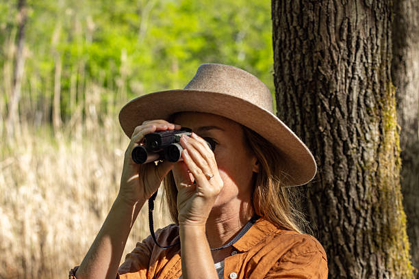 istock Woman Observing Nature with Binoculars in Sunny Park 2211553174