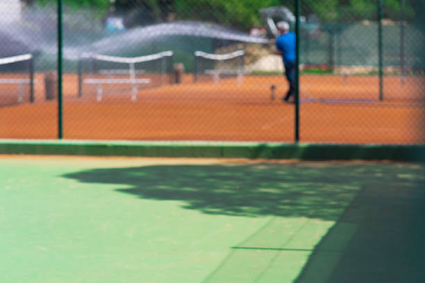 Part of empty used red clay tennis court playground surface with white lines closeup