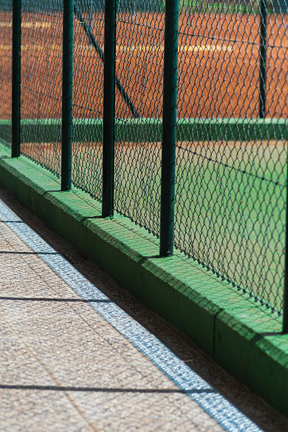 Sunlight and shadow play on an empty tennis court inviting players