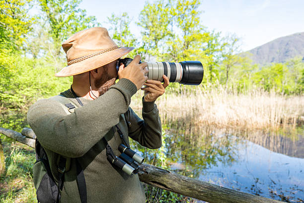 istock Nature Photographer Capturing Serene Wetland Scenery 2211557384