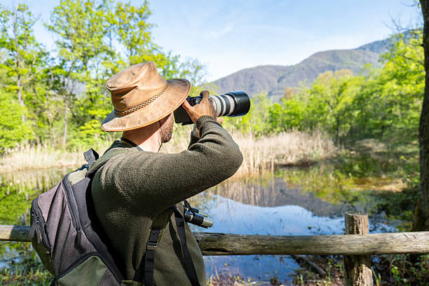 istock Nature Photographer Capturing Serene Wetland Scenery 2211557385