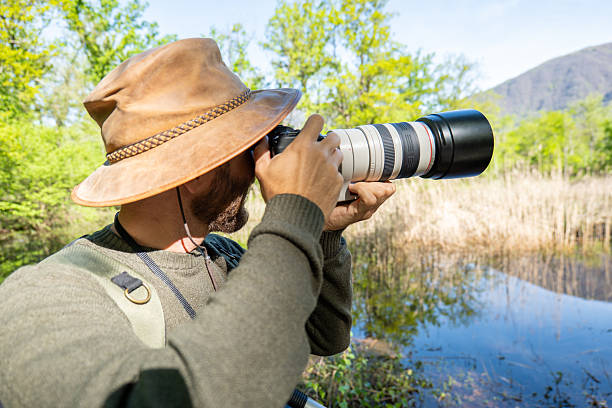 istock Nature Photographer Capturing Serene Wetland Scenery 2211557389