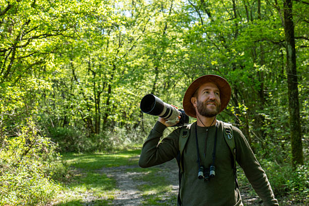 istock Man with Camera in Lush Forest Capturing Nature 2211557535