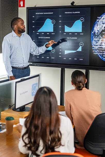 istock Focused Black Businessman Leading a Meeting with Diverse Team in Bright Office Setting 2211558060