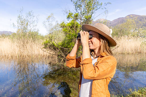 istock Woman Birdwatching at Lakeside 2211558616