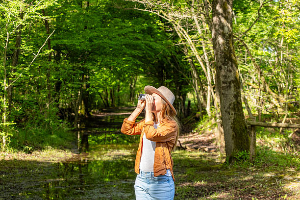 istock Woman Walking Barefoot in Sunlit Forest Path 2211559216