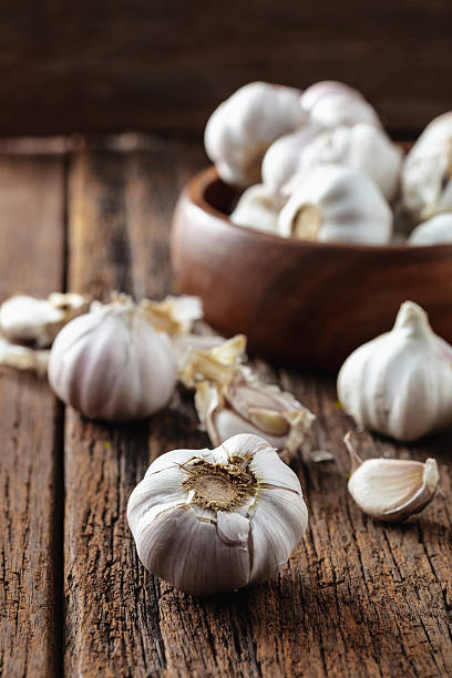istock Fresh Garlic Cloves on Rustic Wooden Table with Bowl Background 2211559324
