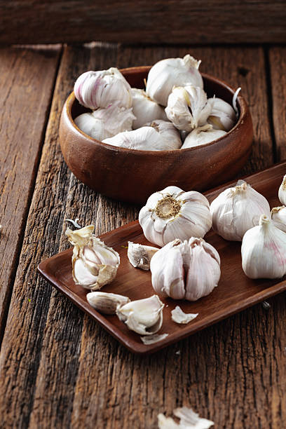 istock Fresh Garlic Cloves on Wooden Table with Rustic Bowl Display 2211559851