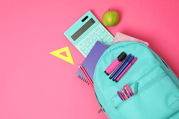 istock Backpack and different school supplies on pink background, flat lay. Space for text 2211560936