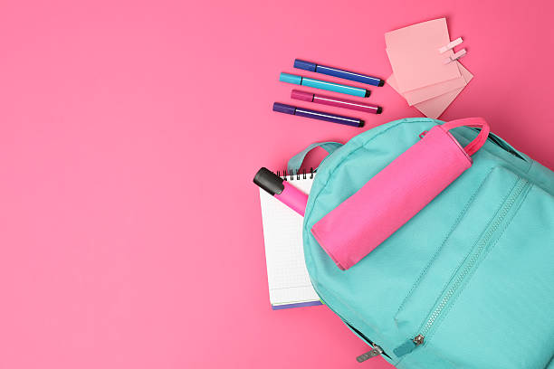 istock Backpack and different school supplies on pink background, flat lay. Space for text 2211560942