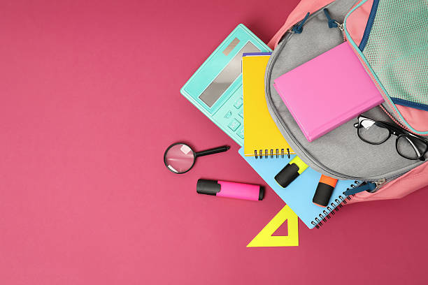 istock Backpack and different school supplies on pink background, flat lay. Space for text 2211560956