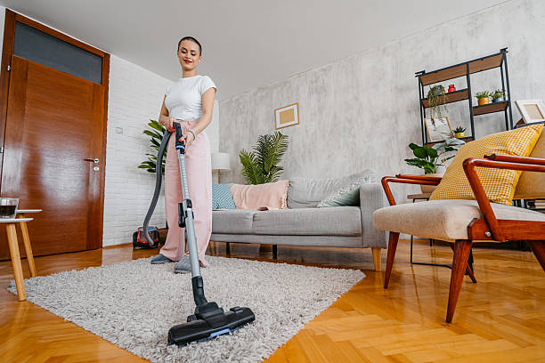 istock Young Woman With A Buzz Cut Vacuuming Her Apartment 2211563694