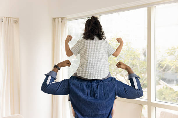 istock Back of strong daddy and kid sitting on fathers shoulders 2211563734