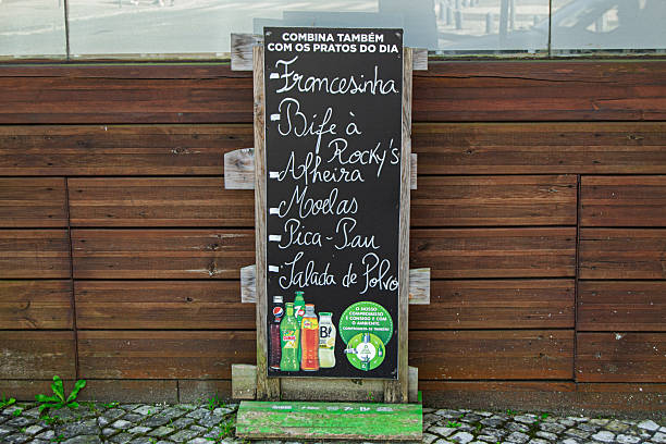 Caldas da Rainha, Portugal - April 17, 2025: Chalkboard displaying a restaurant menu near a wooden wall outdoors