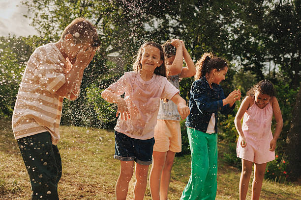 istock Children playing joyfully outdoors with water splashes on a sunny day 2211566930