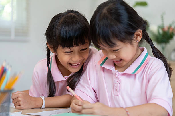 istock Joy and Learning. Two girls enjoying a fun moment while coloring together. 2211567288