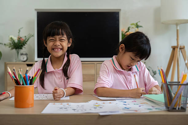 istock Artistic Expression and Collaboration. Two girls engaged in coloring activities, showcasing their creativity. 2211567579
